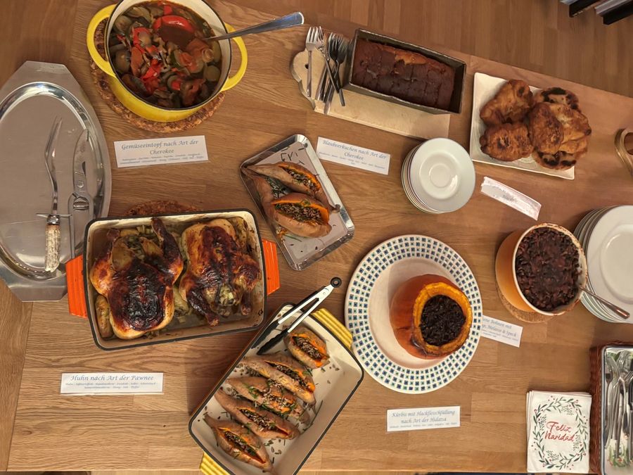 Buffet von oben mit gebratenem Huhn, Gemüseeintopf und handgeschriebenen Speisekarten auf einem Holztisch
